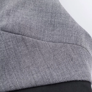 Close-up of grey and black patchwork fabric showing fine stitching on short dress