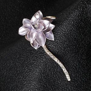 Detailed macro of a purple enamel lotus brooch with sparkling rhinestones on leather