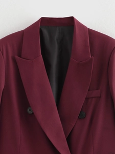 Dettaglio ravvicinato del rever del blazer bordeaux con tessuto e bottoni neri