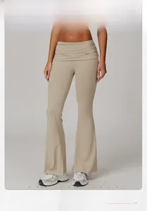 Detail of high waisted beige flare yoga pants with gathered elastic waistband