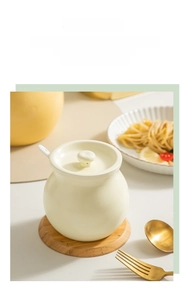 Close-up of cream ceramic oil jar with lid and wooden tray for kitchen storage