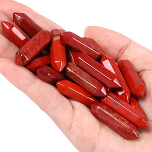 Polished natural red jasper hexagonal crystal point stone held in hand for size visualization