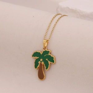 Close-up of golden coconut tree pendant with green and brown enamel leaf details
