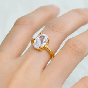 Golden stainless steel ring with faceted oval zircon in a four-prong setting