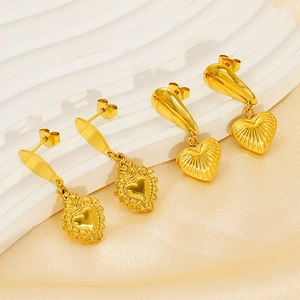 Élégantes boucles d'oreilles cœur dorées aux styles poli et orné sur socle blanc