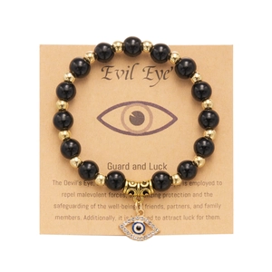 Dettaglio del bracciale occhio greco con perline nere e dorate su cartoncino display
