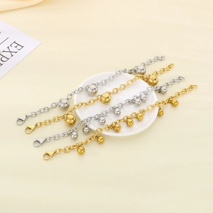 Polished titanium steel ball charm bracelets in gold and silver finish on ceramic plate