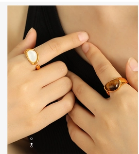 Detail of vintage 18k gold plated titanium rings with tiger eye and white shell stones