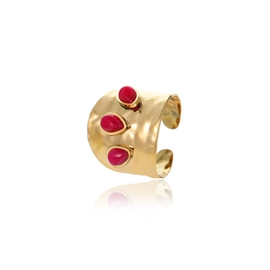 Detail of wide gold hammered cuff ring featuring three red oval stones on white background