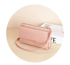 Detail of pink faux leather crossbody wallet with gold hardware and multi-layer zippers