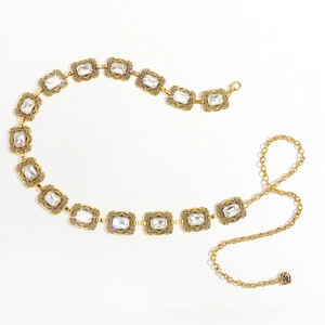 Détail de la chaîne de taille dorée vintage avec cristaux et pendentif rose noire