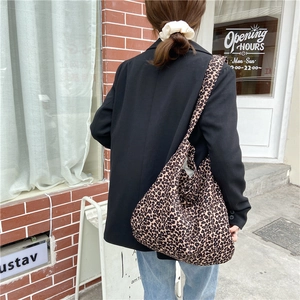 Close-up of leopard print canvas tote bag featuring wide shoulder strap and fabric texture