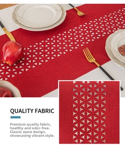 Close-up of red cutout table runner with geometric floral patterns and linen texture