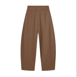 Detail of high waisted brown wide leg trousers with distinct vertical pleated texture