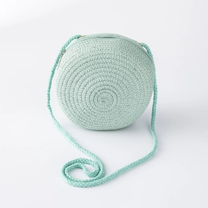 Détail du sac rond en paille tressée vert menthe avec motif de tissage en spirale