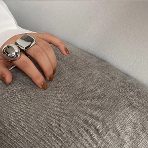 Close-up of polished silver minimalist square and spherical rings on model hand