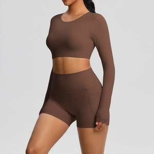 Detail van de yoga short met hoge taille en de crop top met lange mouwen in chocoladebruin
