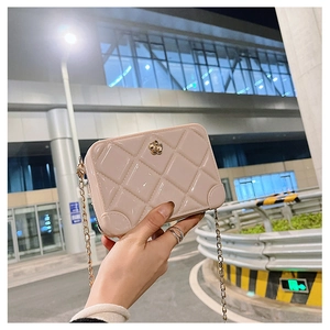 Detailed view of beige PVC quilted jelly bag featuring a golden flower clasp and chain