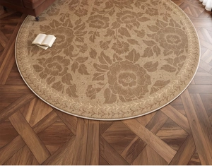 Top view of round retro floral carpet with woven texture on dark wooden floor