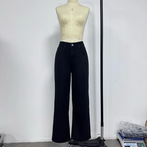 Detail view of washed black wide-leg denim jeans on a professional mannequin stand