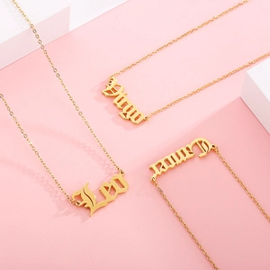 Golden zodiac necklaces with Virgo and Leo gothic pendants on pink background