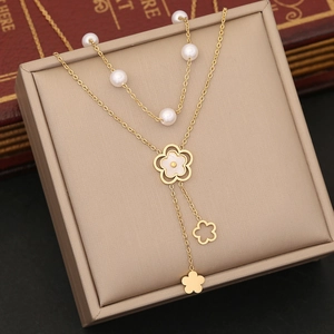 Close-up of double-layer gold pearl necklace with floral tassels in a jewelry box