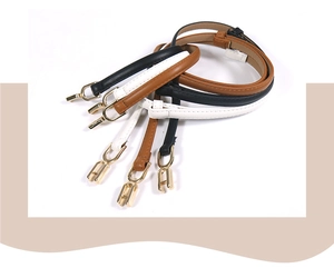 Detailed view of thin leather belts in black, brown, and white with golden metal buckles
