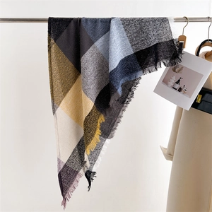 Detail of colorful plaid scarf showing woven fabric texture and delicate fringe tassels