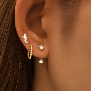 Macro detail of gold S925 silver earring set with sparkling white cubic zirconia