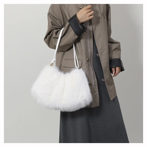 Détail du sac à bandoulière en fausse fourrure blanche porté par un mannequin