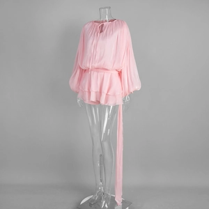 Detail of pink chiffon dress featuring lantern sleeves, tie-neckline and tiered ruffles