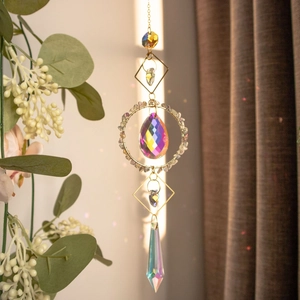 Close-up of golden suncatcher with natural crystals creating rainbow light reflections