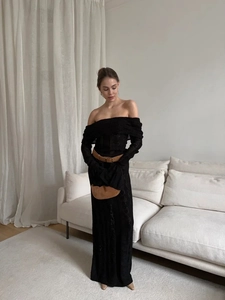 Close-up of black off-shoulder knit dress featuring textured hollow out crochet details