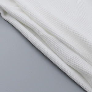 Close-up of white ribbed knit fabric showing soft texture and detailed vertical patterns
