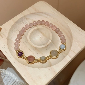 Detailed top view of natural amethyst and quartz beads with gold plated serpent accents