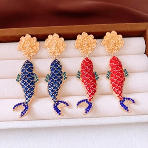 Macro detail of Chinese style koi fish earrings with enamel scales and floral metal studs