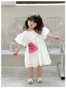 Pink pearl strap mini bag shown with girl's white puff sleeve dress in modern setting