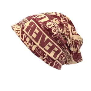 Hip hop style knitted slouchy beanie featuring a vintage newspaper print in burgundy and beige