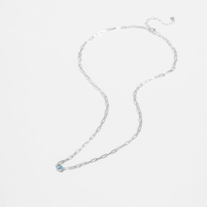 Detail of S925 sterling silver paperclip chain necklace with a blue gemstone pendant