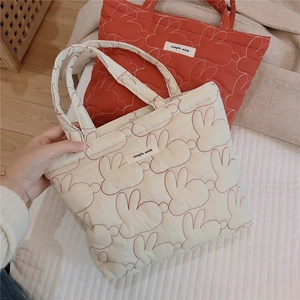 Close-up of quilted rabbit pattern fabric and simple wish label on the padded handbag