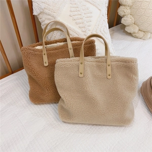 Detail of teddy fleece tote bags in caramel and beige with faux leather handles