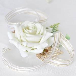 Elegant white artificial rose boutonniere with gold leaf and ribbon for wedding ceremony