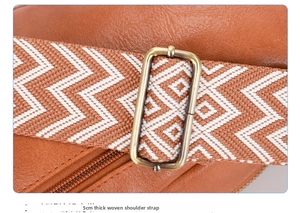 Detailed macro of 5cm wide woven geometric shoulder strap and bronze metal buckle