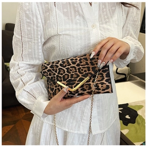 Detail of leopard print envelope bag with gold V-buckle and metallic chain strap