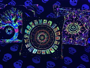 Macro shot of glow-in-the-dark Bohemian pillows with UV-reactive Tree of Life and star patterns