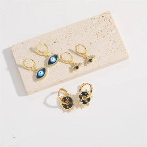 Set di tre paia di orecchini placcati oro con occhio del diavolo e luna su vassoio