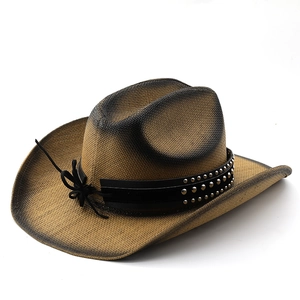 Close-up of vintage straw cowboy hat featuring metal rivets on a black leather band
