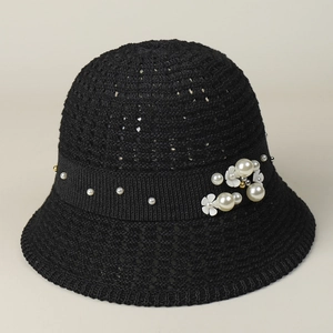 Detail of elegant black crochet bucket hat featuring pearl and flower embellishments