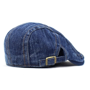 Detail of blue denim ivy cap featuring yellow contrast stitching and metal side buckle