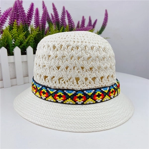 Close-up of hollow-out weave pattern and colorful ethnic ribbon on cream sun hat